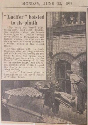 Faded newspaper cutting with the headline Lucifer hoisted to it's plinth. The staue of Lucifer can be seen on it's back with a chain around it's body, lbeing lifted into the air.