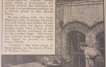 Faded newspaper cutting with the headline Lucifer hoisted to it's plinth. The staue of Lucifer can be seen on it's back with a chain around it's body, lbeing lifted into the air.