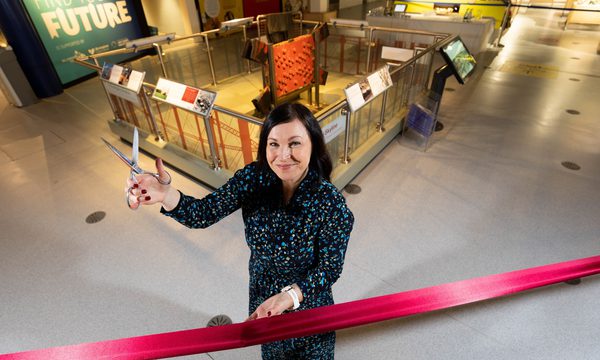 Sarah Rea Land holding a pair of scissors ready to cut a ribbon to open the gasholders exhibition