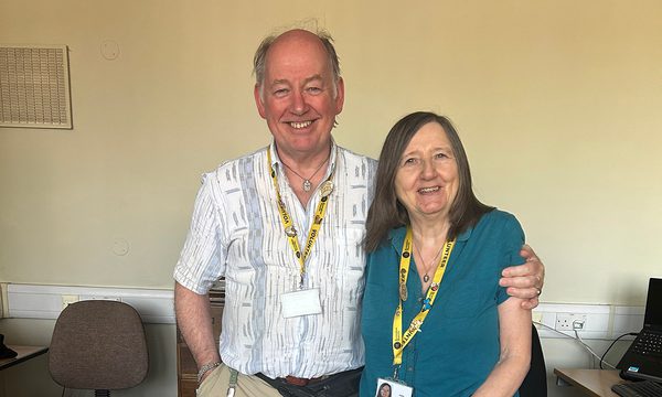 Two volunteers standing together smiling.