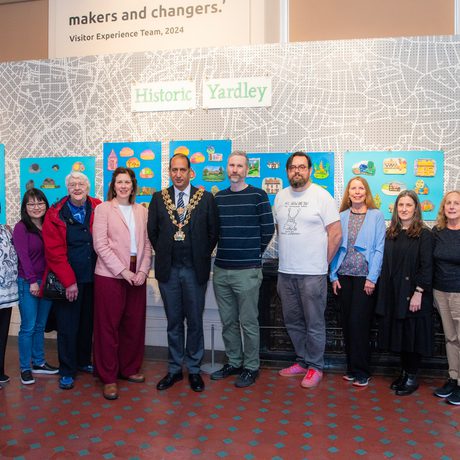 A group of artists and participants and the mayor in front of the Historic Yardley display.