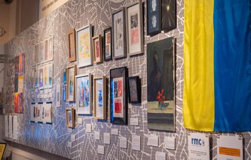Image shows a cropped section of colourful artwork, including self-portraits and block printing. There is the yellow and blue national flag of Ukraine in the right of the image.