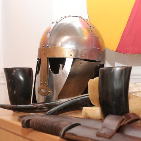 A group of replica Anglo-Saxon objects including a helmet and shield.