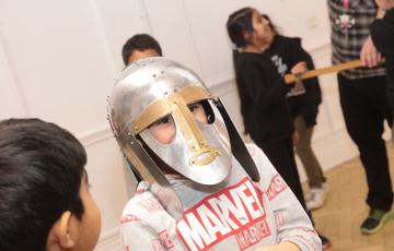 A child wearing a replica Staffordshire Hoard helmet.