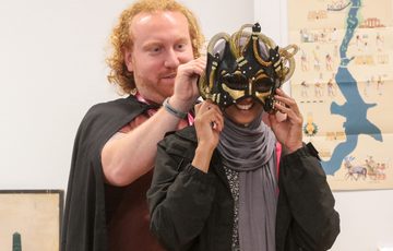 A staff member putting a mask on an adult.