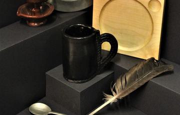 Tudor items including mug, spoons, quill pen, plate