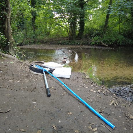 Nets and plastic trays on the side of the river, ready for pond dipping.