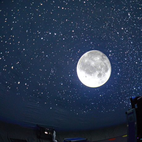 Inside a mobile planetarium with stars and moon in the night sky.