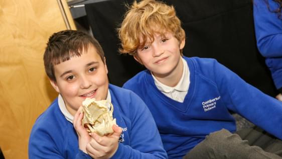 Two school children one of which is holding a skull