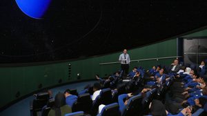 A group of school children sitting in the Planetarium.
