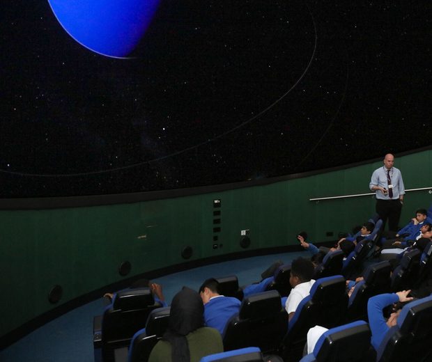 A group of school children sitting in the Planetarium.