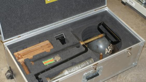 An image of a metal box containing some wooden and metal instruments