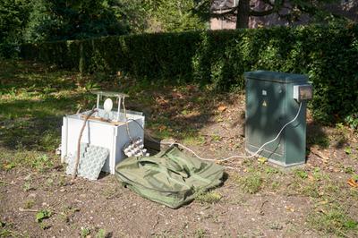Moth trapping equipment connected to a power source, set up outside on the grass.
