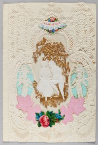 Intricate lacework card with a romantic couple, cherubs, floral accents, and "A Lovers Gift" banner at top.