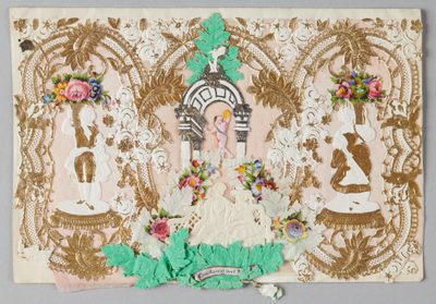 Intricate Victorian lace paper art, cherub centrepiece, floral accents, gold and green embellishments.