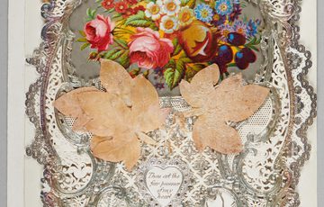 Ornate lace-bordered card with colourful flowers, leaves, and a small heartfelt message.