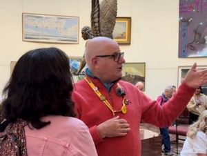 A volunteer talking to a visitor in a gallery setting.