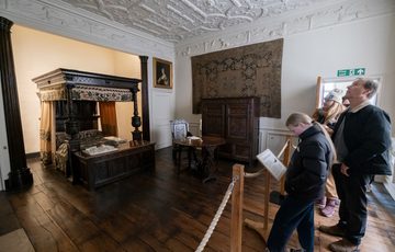 Visitors in the a bedroom with four poster bed.