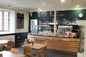 The café counter with tables and chairs in front of it.