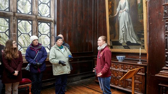 A small group of people admiring something out of view in an art gallery