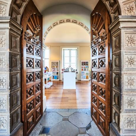 Arched entrance to gift shop with fancy stone columns and carved doors