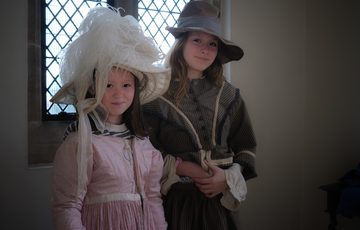 Two children dress up in historical costume.