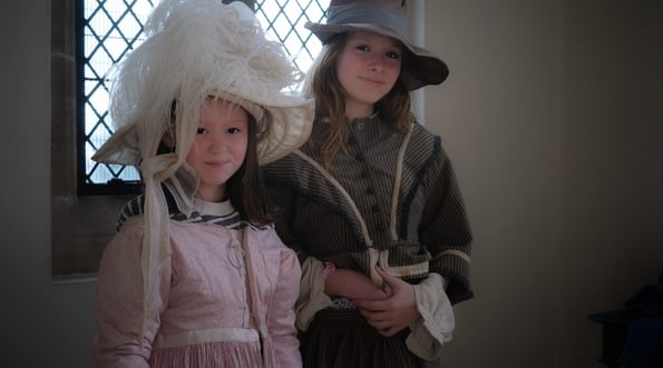 Two children dress up in historical costume.