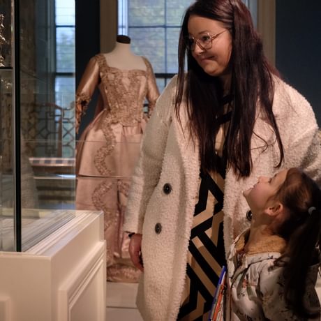 A adult and child looking into a display case.