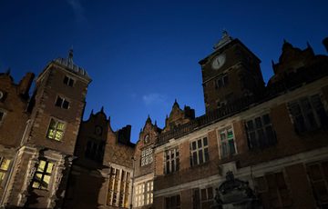 View looking up at the exterior of Aston Hall Jacobean building at night, dimly lit from the inside.