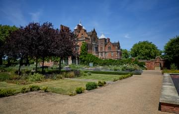 Pathway, grass and trees in the garden, with Aston Hall Jacobean house in background.