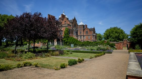 Pathway, grass and trees in the garden, with Aston Hall Jacobean house in background.