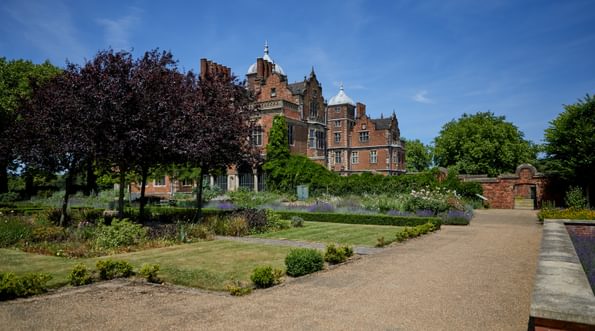 Pathway, grass and trees in the garden, with Aston Hall Jacobean house in background.