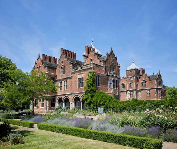 Exterior view of the rear of a Jacobean Hall and flower garden