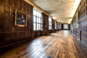 Jacobean wood-panelled Long Gallery with leaded windows and ornate plaster ceiling