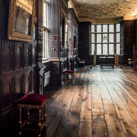Jacobean wood-panelled Long Gallery with leaded windows and ornate plaster ceiling