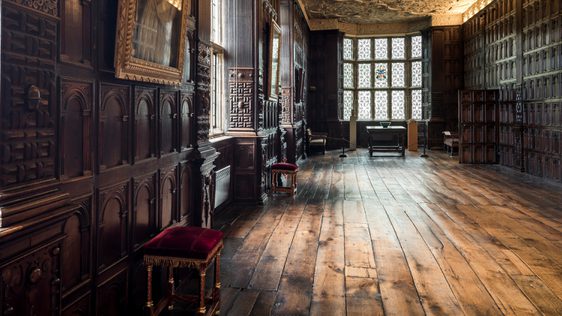 Jacobean wood-panelled Long Gallery with leaded windows and ornate plaster ceiling