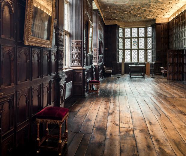 Jacobean wood-panelled Long Gallery with leaded windows and ornate plaster ceiling