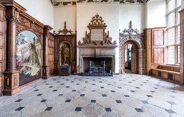 Large entrance hall with chequered stone floor and ornate fireplace