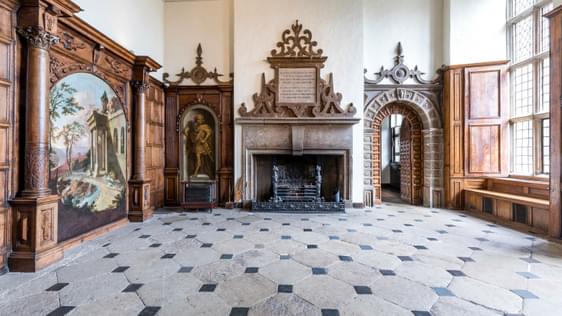 Large entrance hall with chequered stone floor and ornate fireplace