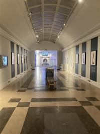 A bridge gallery with photographic portraits on each side and at the end.