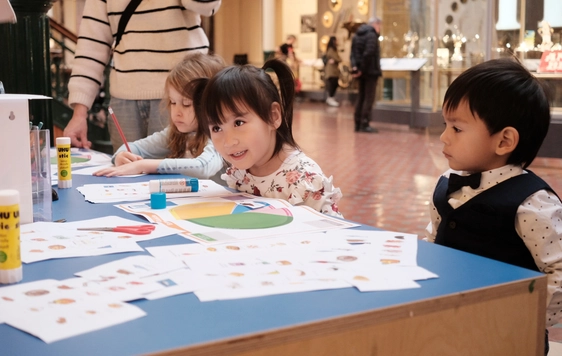 Children sitting at a table doing an activity.
