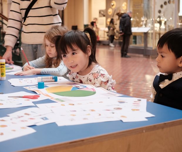 Children sitting at a table doing an activity.