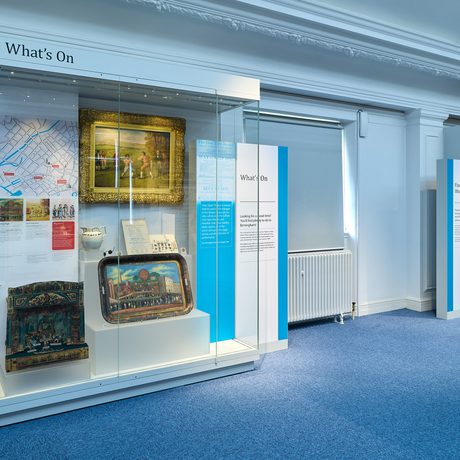 A display case featuring a japanned tray, painting and puppet show.