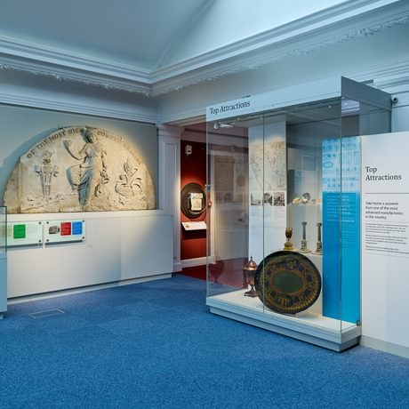 A wide angle of a display featuring a vairty of objects including a wooden door and stone carving.