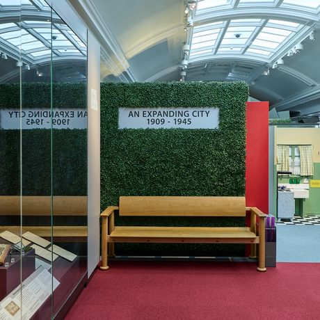 A display sign that reads 'An expanding city' on a hedge.