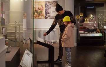 An adult and child looking a interactive on display.