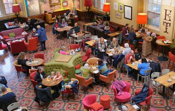 A busy museum tearoom viewed from above.
