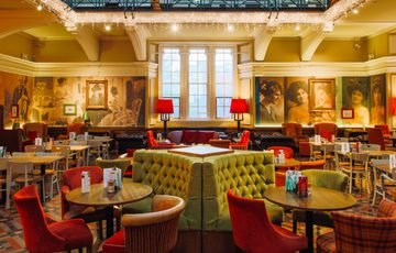 The tearoom space with table, chairs, sofa's and booths with icicle lights hanging.