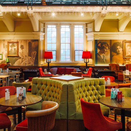 The tearoom space with table, chairs, sofa's and booths with icicle lights hanging.