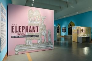 Large pink graphic signage that reads 'Elephant in the room display' with illustration elephant artefact.